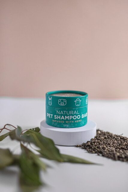 hemp collective pet shampoo bar on white stand with seeds and leaves