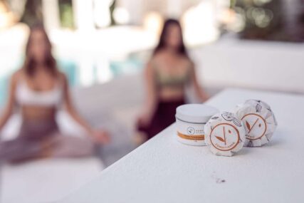 hemp collective lemongrass and grapefruit conditioner bar and tin in front of women by pool doing yoga