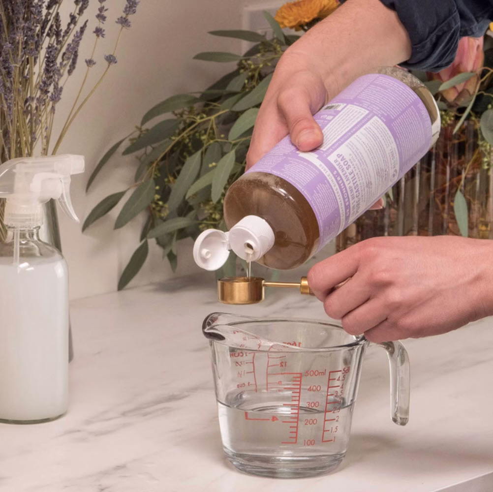 Pouring Dr' Bronner's Lavender Castile soap 937ml into jar