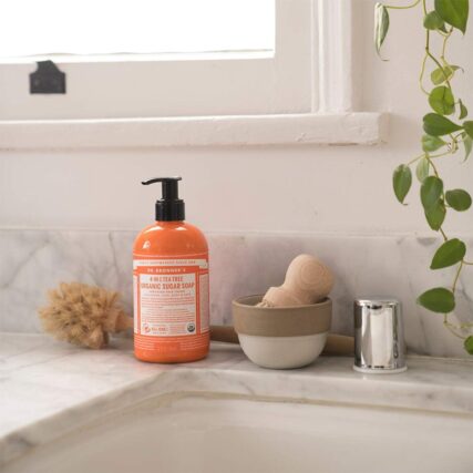 Bathroom sink with Dr. Bronner's Organic Pump Soap Tea Tree next to shaving brush