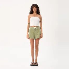 Model wearing the Afends Ellia Boardshorts in Sage with a white tank, full-length front view